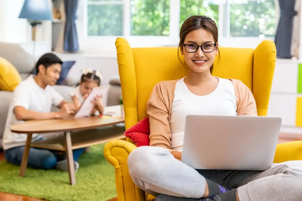 Woman smiling while working on a laptop at home, representing legit work from home jobs that pay weekly for beginners.