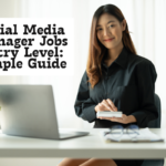 Woman working at a desk with a laptop and phone, representing social media manager jobs entry level for beginners.